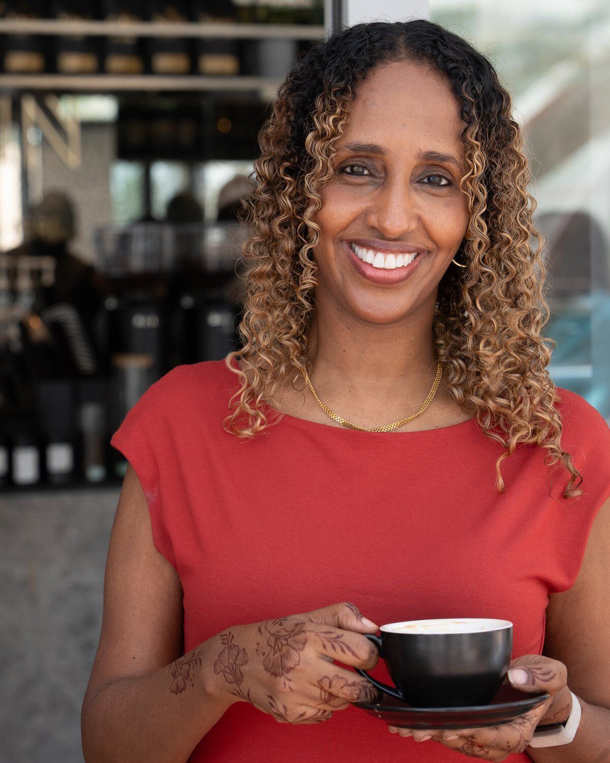 Orit Mohammed, founder of Boon Coffee, holding a cup at a Boon café