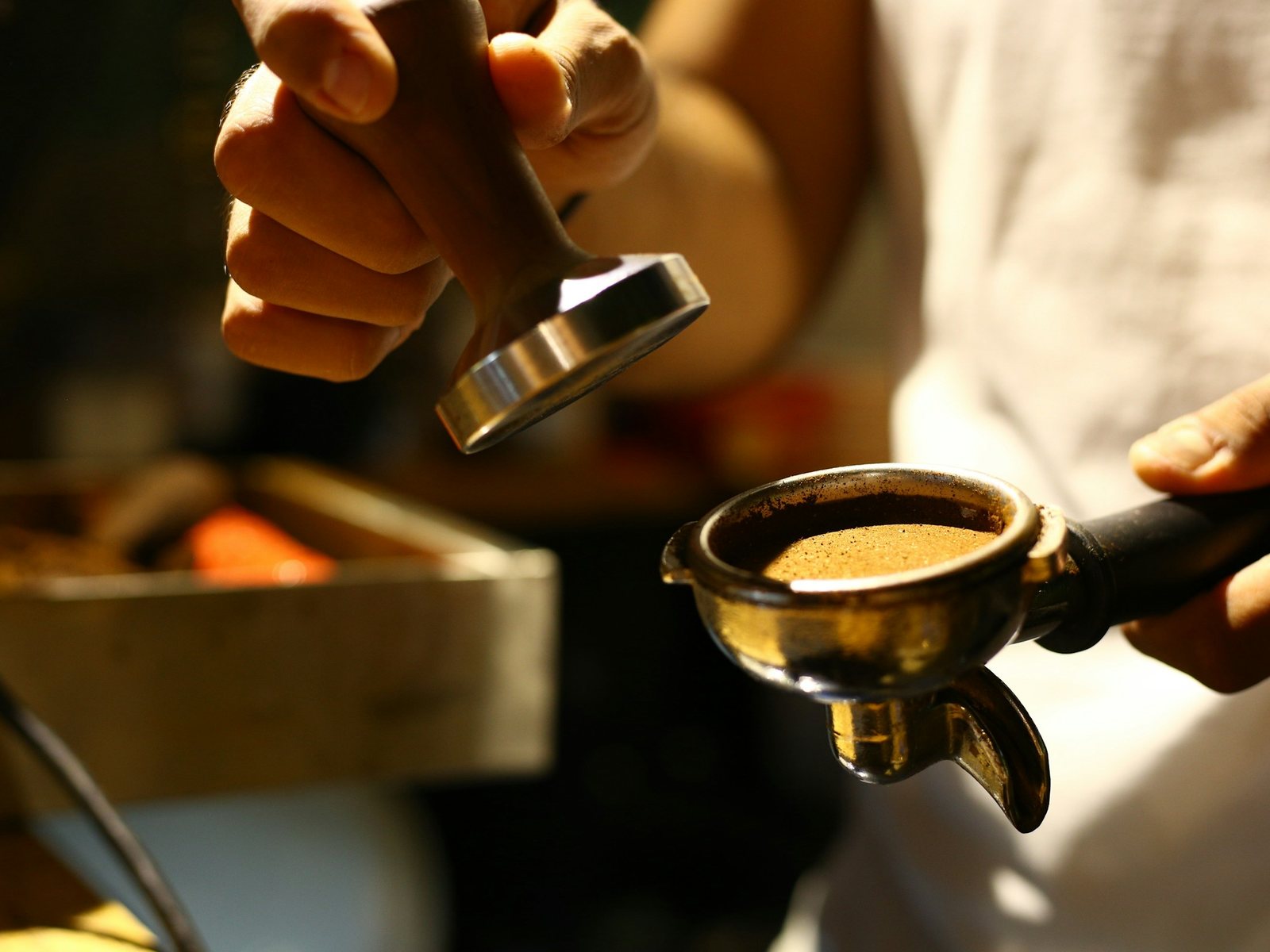 A technician checking a portafilter at the espresso machine